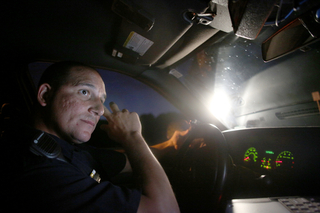 Officer Mike Gabriell, a DPS officer of three years, shines a spotlight on Thornden Park after a supposed shots-fired call that turned out to be fireworks. DPS has seen an increase in calls this past weekend with the arrival of students on campus.  