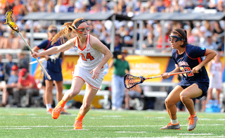 SU midfielder Bridget Daley holds her cradle away from UVA midfielder Daniela Eppler.