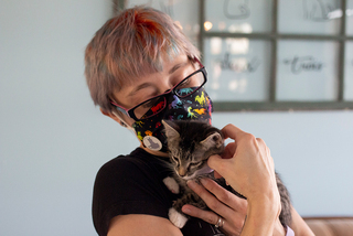 Alisha Reynolds, the owner of Pawsitivitea CNY Cafe & Cat Lounge, holds a kitten named Ollie.